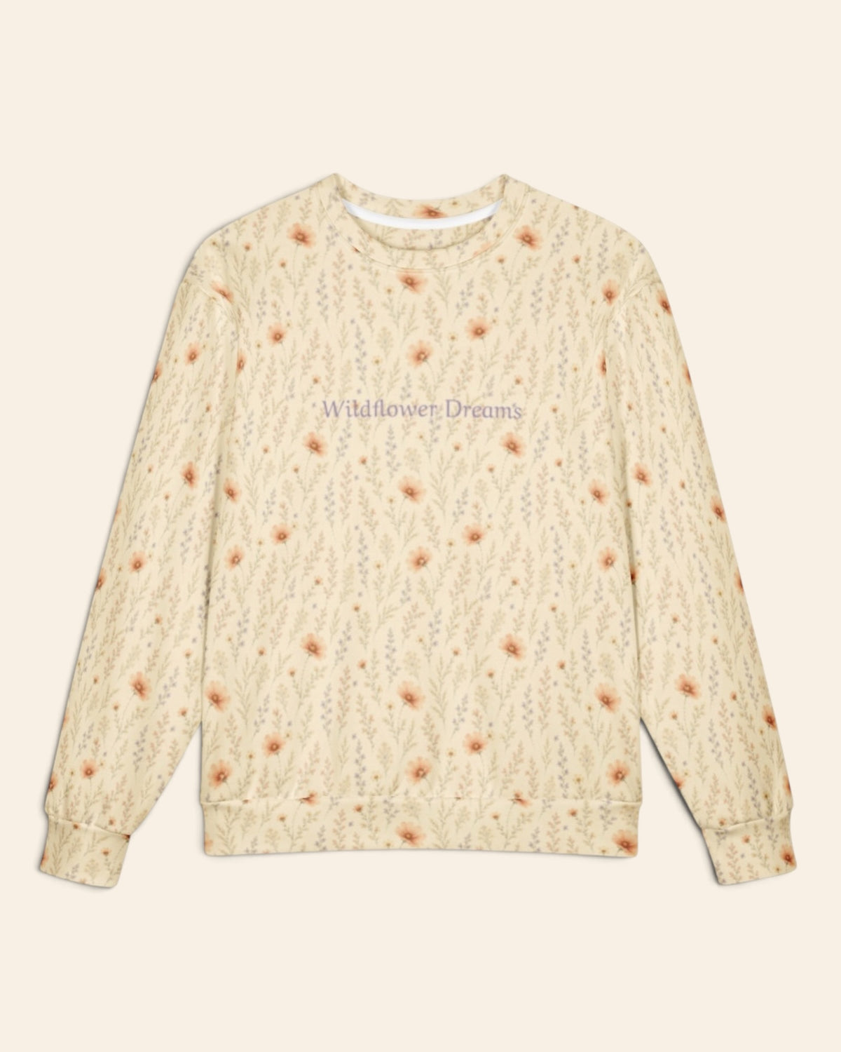 The oversized crewneck sweatshirt shown flat from the front on a plain cream background, sleeves out, cuffs and waistband ribbed. The all-over print is warm cream, printed with apricot cosmos blooms among fine sage stems, with the words Wildflower Dreams in a small script across the chest.