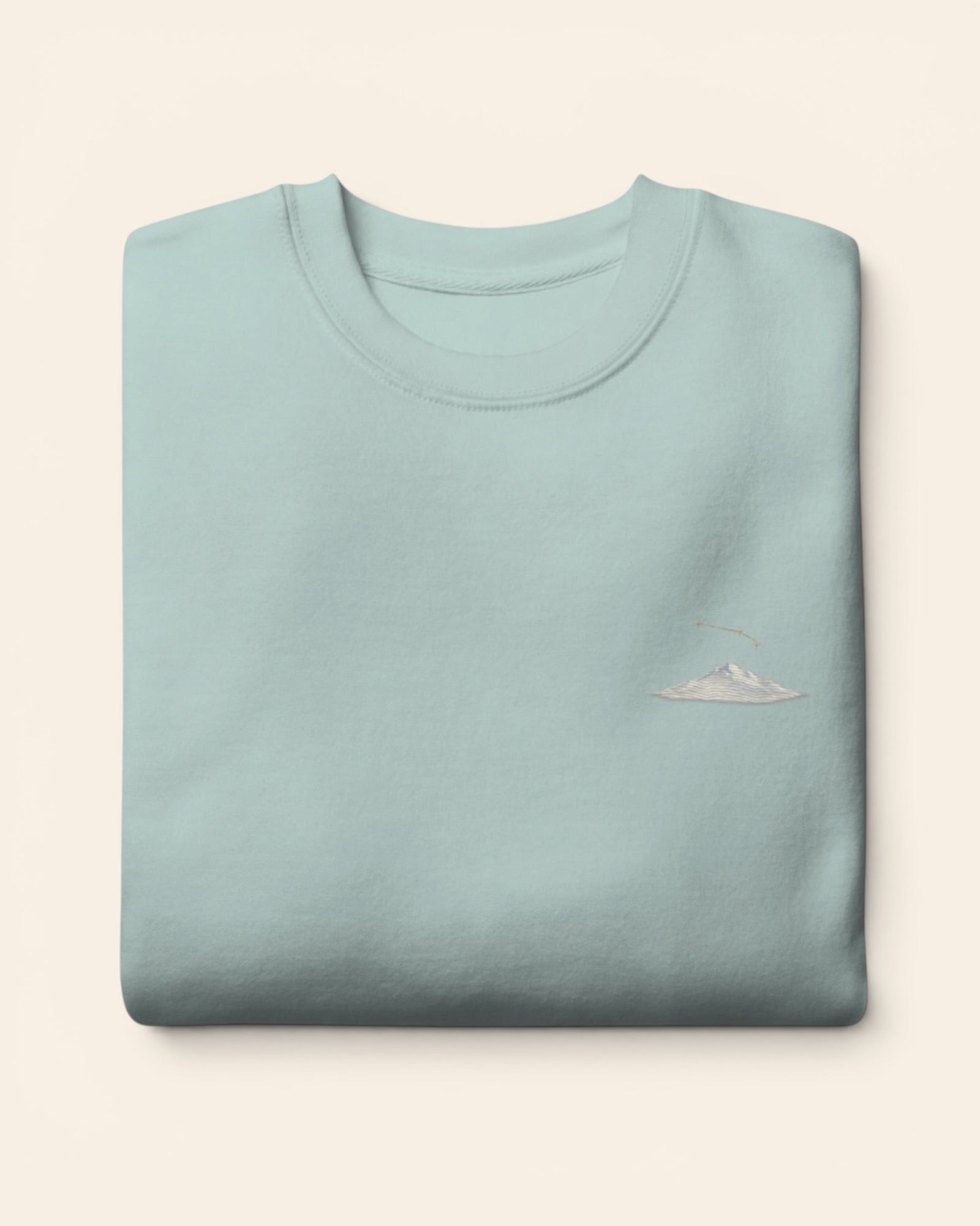 Aries constellation crewneck sweatshirt with embroidered stars above a mountain ridge, in Agave