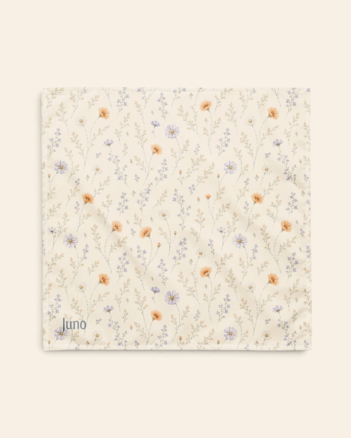 The bandana laid flat as a full square on a cream background, the print running on the diagonal. It is white, printed with small apricot poppies and lilac and periwinkle wildflowers on fine stems, with the sample name Juno printed in the lower left corner.