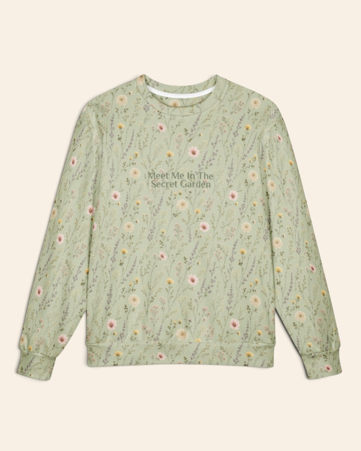 The oversized crewneck sweatshirt shown flat from the front on a plain cream background, sleeves out, cuffs and waistband ribbed. The all-over print is sage green, printed with white and pink daisies and fine wildflower stems, with the words Meet Me In The Secret Garden in a small script across the chest.