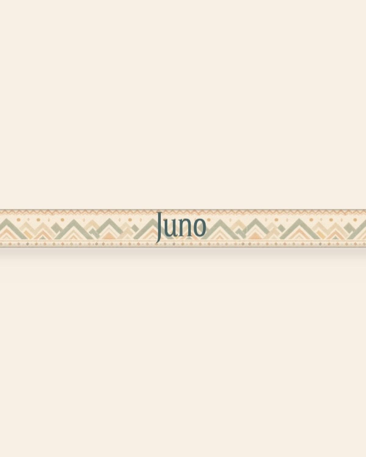A close, straight-on crop of the leash strap laid flat on a cream background, showing the print and the sample name Juno running along the webbing. The strap is cream, banded with sage and apricot chevrons and diamond geometric motifs.