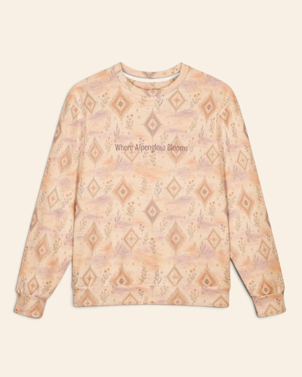 The oversized crewneck sweatshirt shown flat from the front on a plain cream background, sleeves out, cuffs and waistband ribbed. The all-over print is a peach and apricot wash set with cream diamond medallions and fine wildflower sprigs, with the words Where Alpenglow Blooms in a small script across the chest.
