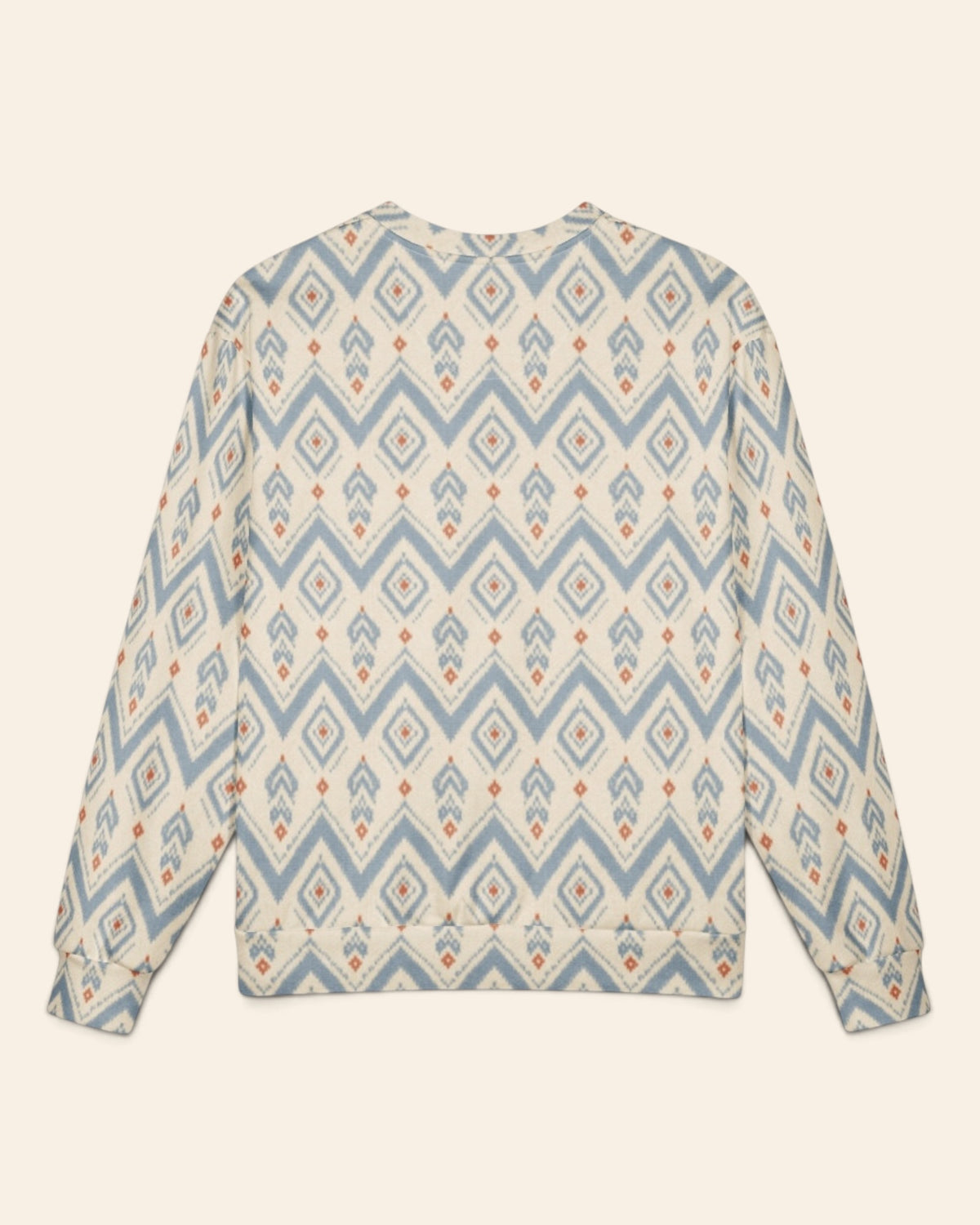 The same crewneck shown flat from the back on a plain cream background, with no text, so the all-over print runs unbroken across the body and sleeves. It is cream, printed with dusty blue chevrons and stepped diamond medallions with rust accents.