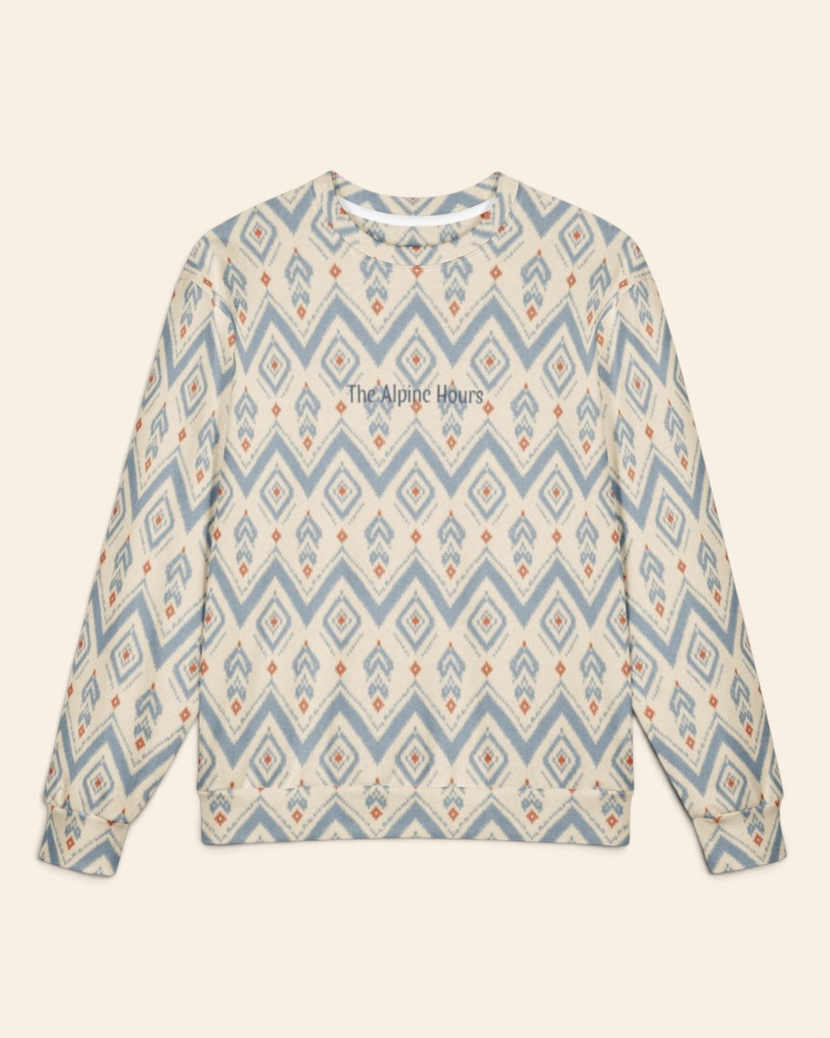 The oversized crewneck sweatshirt shown flat from the front on a plain cream background, sleeves out, cuffs and waistband ribbed. The all-over print is cream, printed with dusty blue chevrons and stepped diamond medallions with rust accents, with the words The Alpine Hours in a small script across the chest.