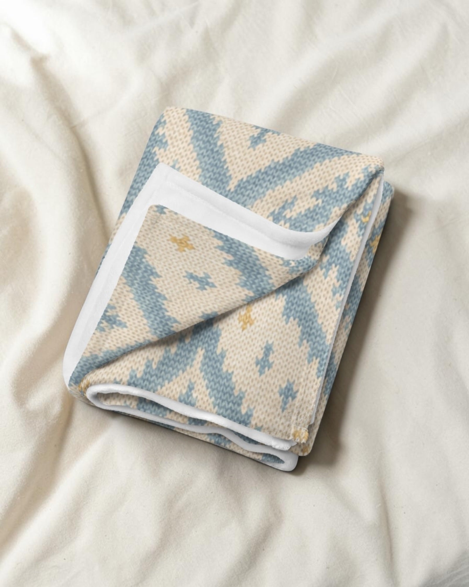 A Place Between The Peaks Throw Blanket, with dusty blue ikat-inspired diamonds and soft golden accents print