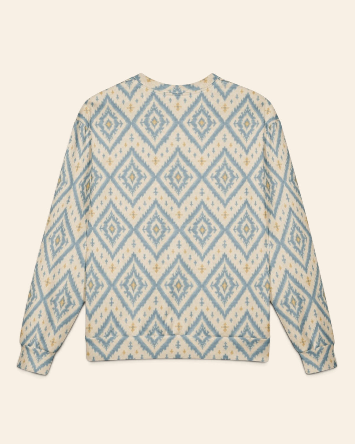 The same crewneck shown flat from the back on a plain cream background, with no text, so the all-over print runs unbroken across the body and sleeves. It is cream, printed with large dusty blue ikat diamonds outlined in gold with small cross motifs.
