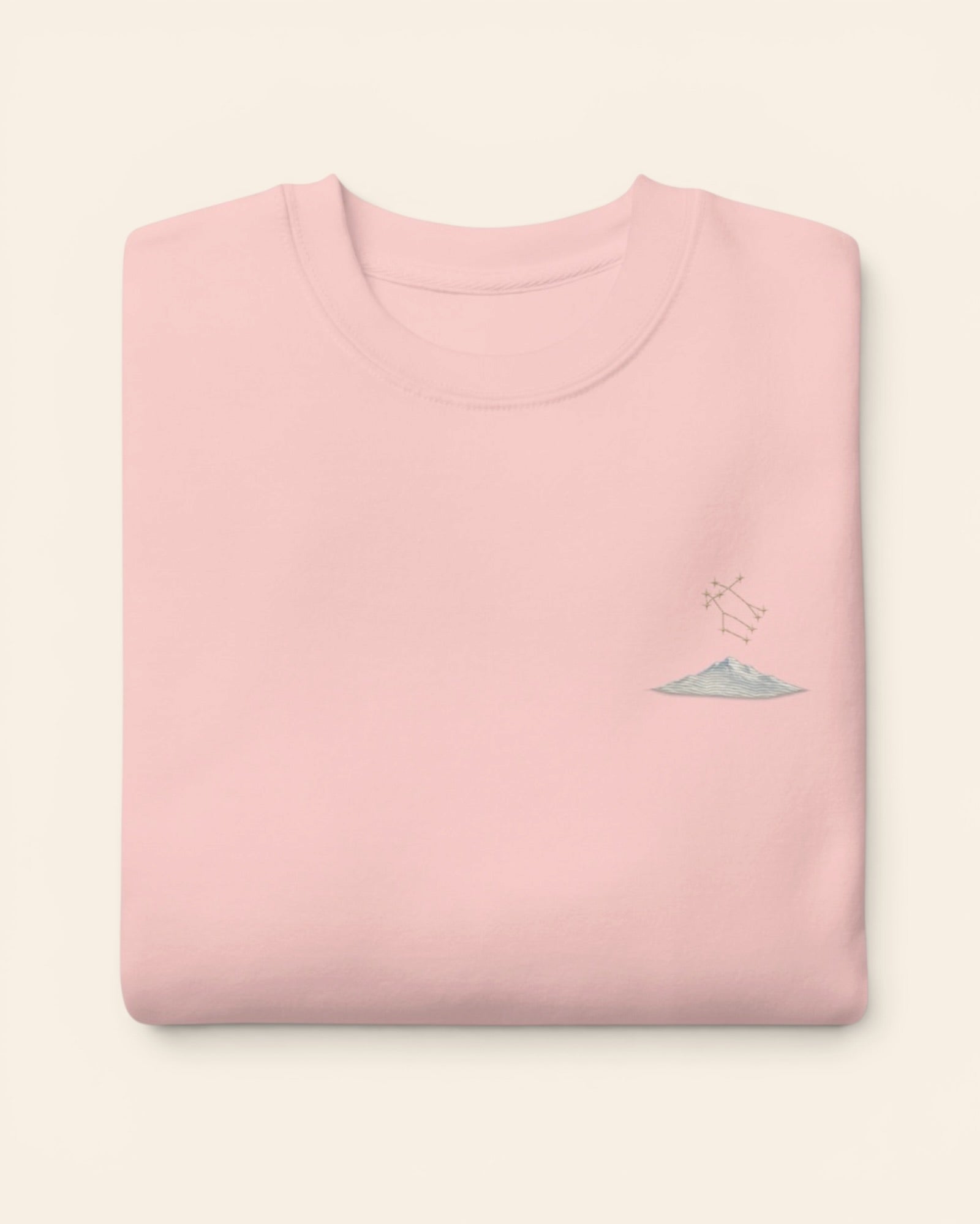 Gemini constellation crewneck sweatshirt with embroidered stars above a mountain ridge, in Light Pink