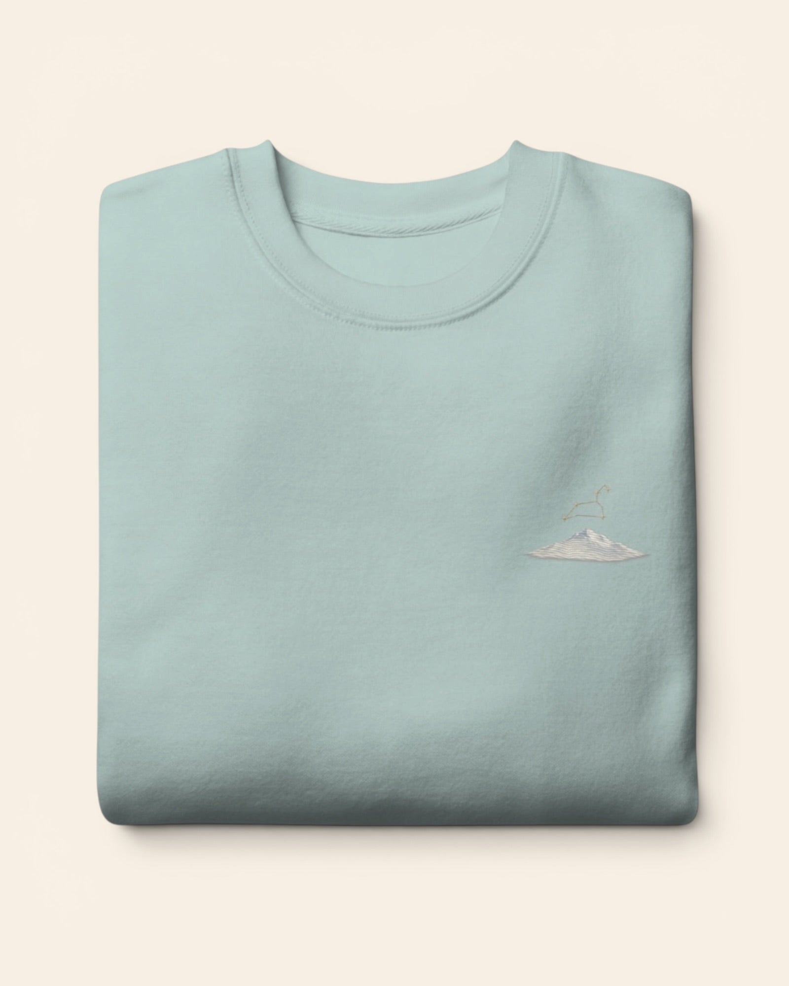 Leo constellation crewneck sweatshirt with embroidered stars above a mountain ridge, in Agave