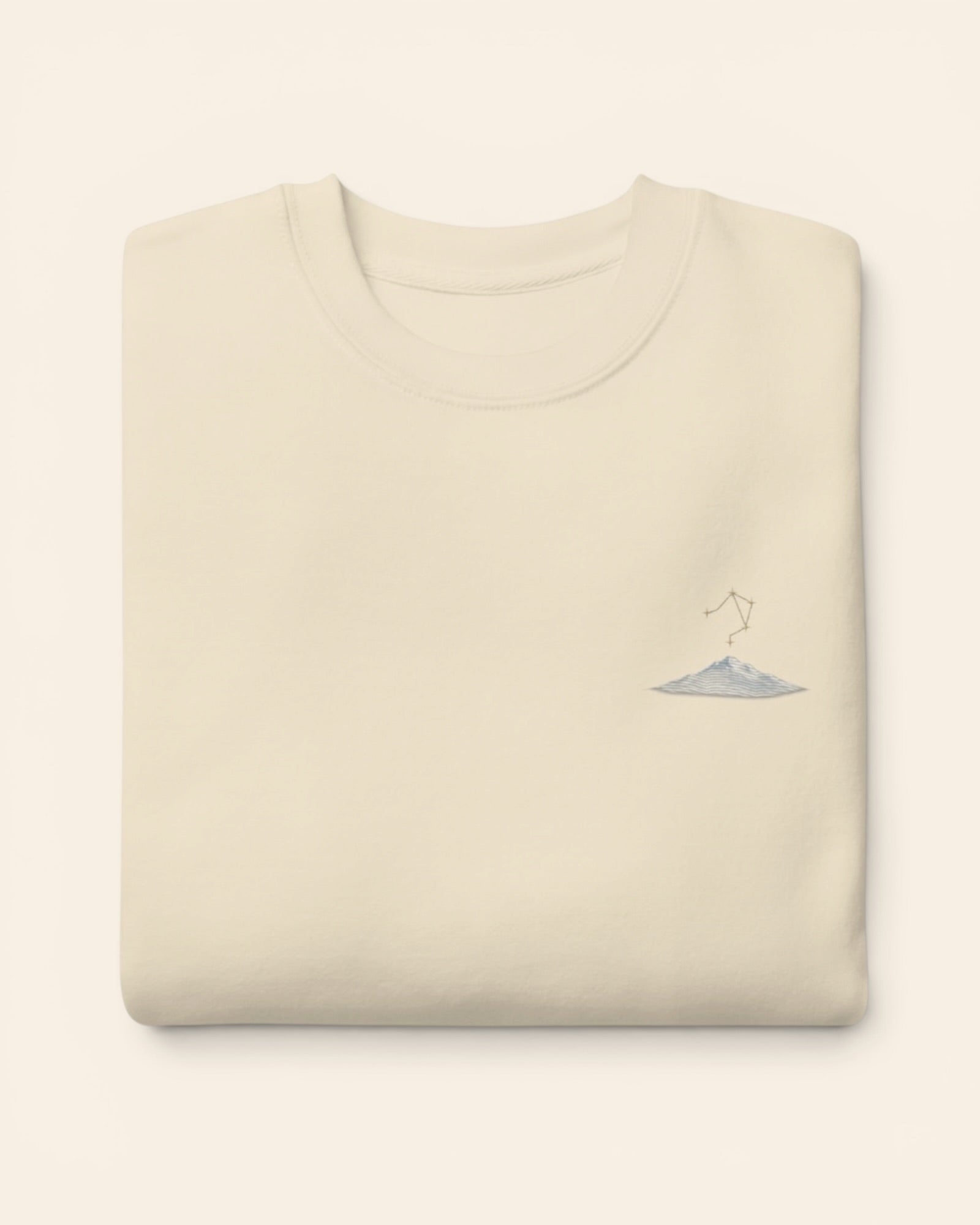 Libra constellation crewneck sweatshirt with embroidered stars above a mountain ridge, in Bone
