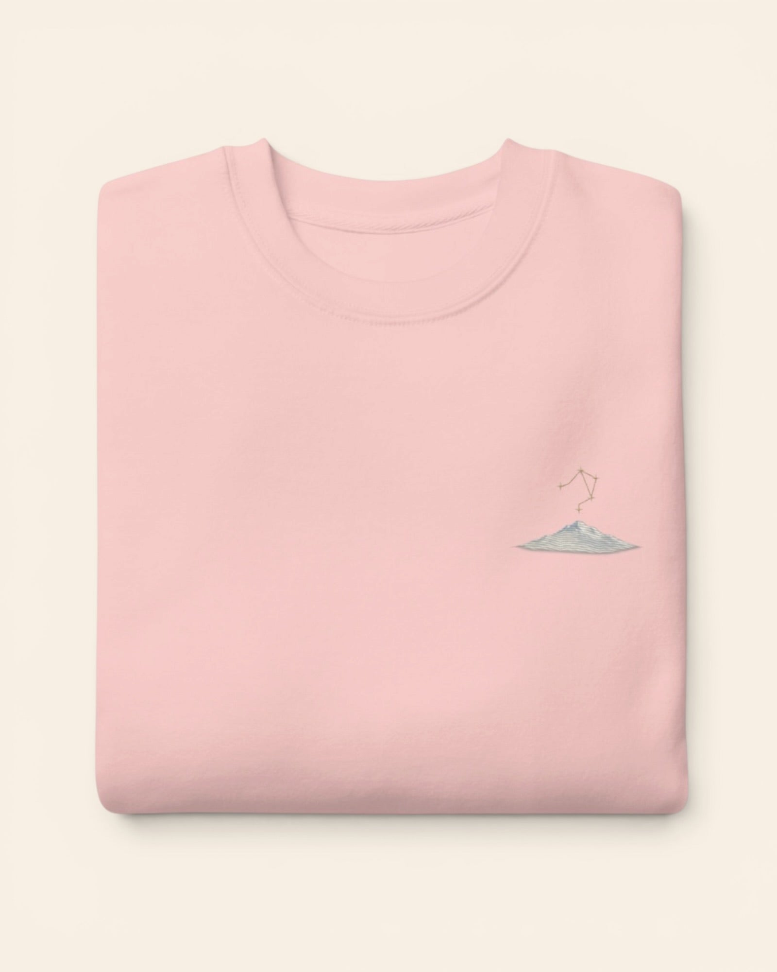 Libra constellation crewneck sweatshirt with embroidered stars above a mountain ridge, in Light Pink