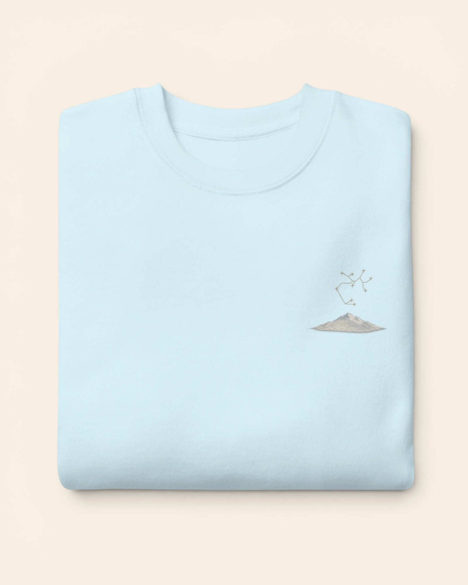 Sagittarius constellation crewneck sweatshirt with embroidered stars above a mountain ridge, in Sky Blue