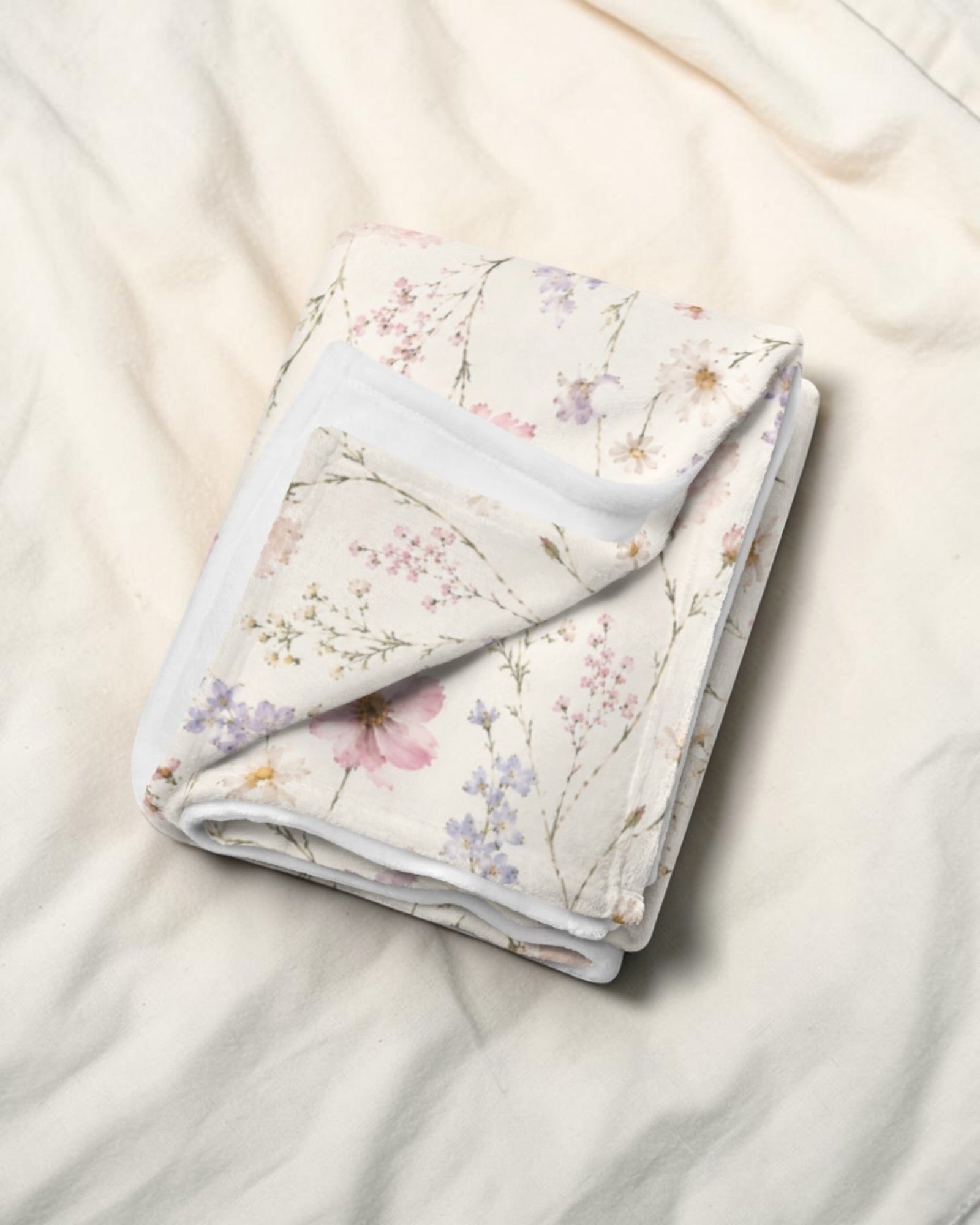 The Wildflower Theory Throw Blanket, with blush cosmos, cottage roses, larkspur, and baby's breath print
