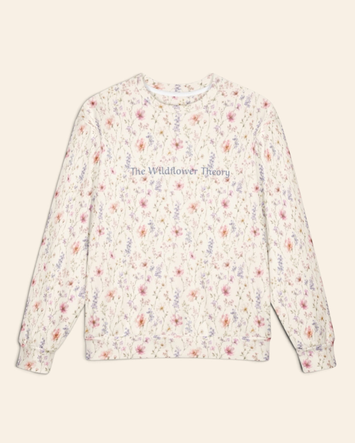 The oversized crewneck sweatshirt shown flat from the front on a plain cream background, sleeves out, cuffs and waistband ribbed. The all-over print is white, densely printed with blush cosmos and lilac and periwinkle wildflowers, with the words The Wildflower Theory in a small script across the chest.